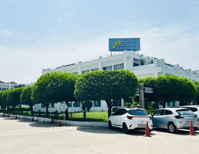 A multi-storey white building with a hospital signboard on top