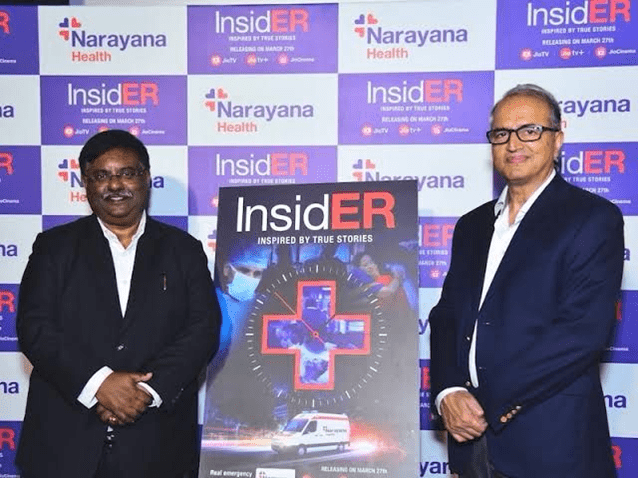 2 senior professionals posing on either side of the poster showing an official unveiling or launch